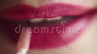 丰满的女人嘴唇。 女人的嘴唇上贴着红色的口红。 唇瓣情绪特写..